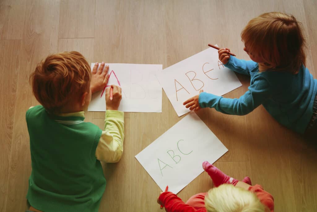 Kids drawing letters on paper